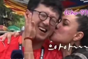 熱情女球迷韓國(guó)一記者在墨西哥報(bào)道世界杯，被球迷摟住親臉頰